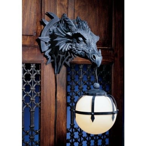 Dragon head on wall holding a light globe